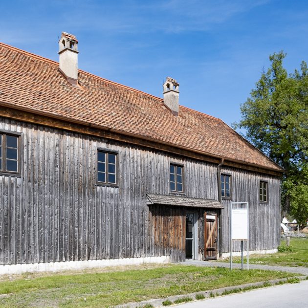 Das Bild zeigt die mit Holz verkleidete Fassade der ehemaligen Glashütte, in der Fraunhofer Glas herstellte.